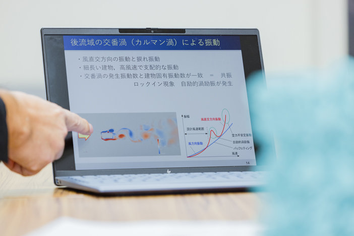 パソコンの画面上で、カルマン渦の概念図を指で示す様子